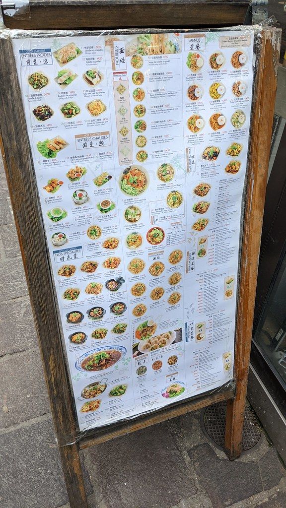 A traveler using a translation app on a phone in a Chinese street market