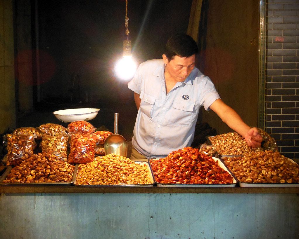 A night market street scene with food stalls and neon in China
