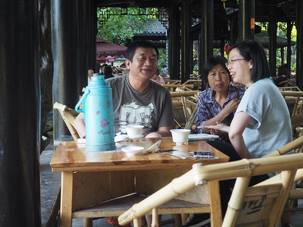 Bamboo chairs and covered tea cups at an outdoor teahouse in Chengdu's People's Park