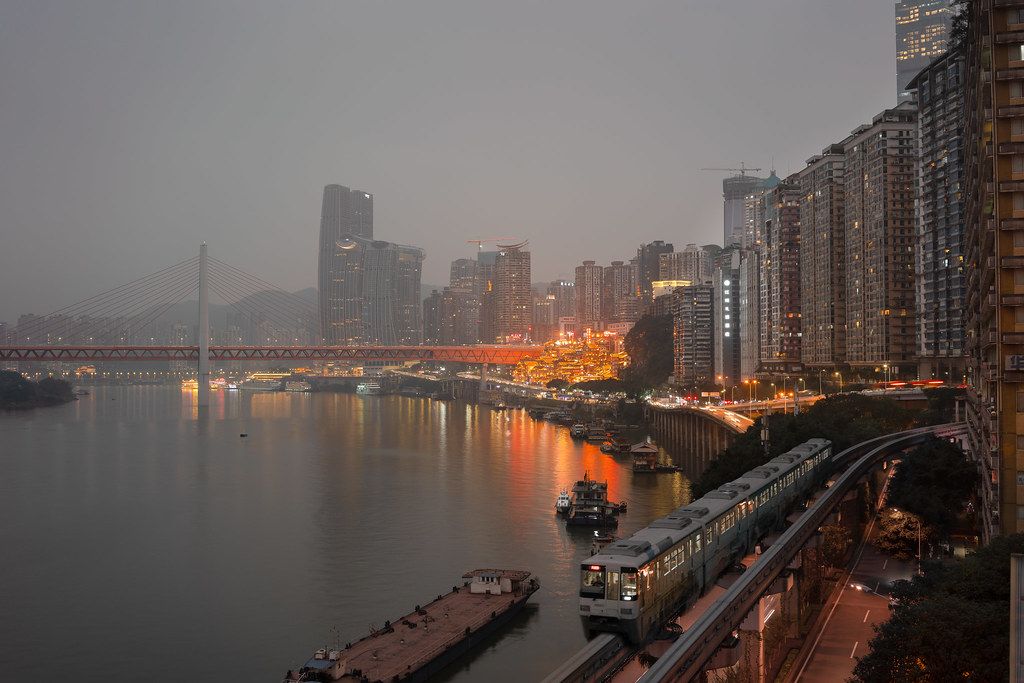 Chongqing Hongya Cave glowing at night from across the river