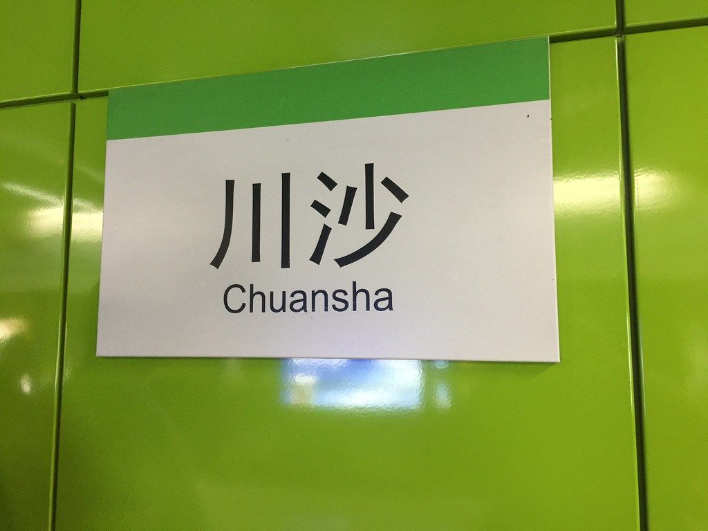 A bright, clean Chinese metro station platform with bilingual signage