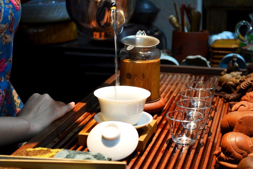 Pouring tea into small cups during a meal