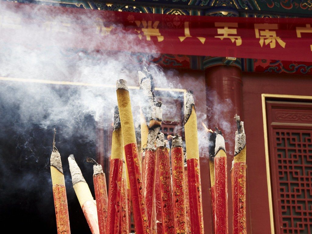 A visitor standing quietly and respectfully inside a Chinese temple
